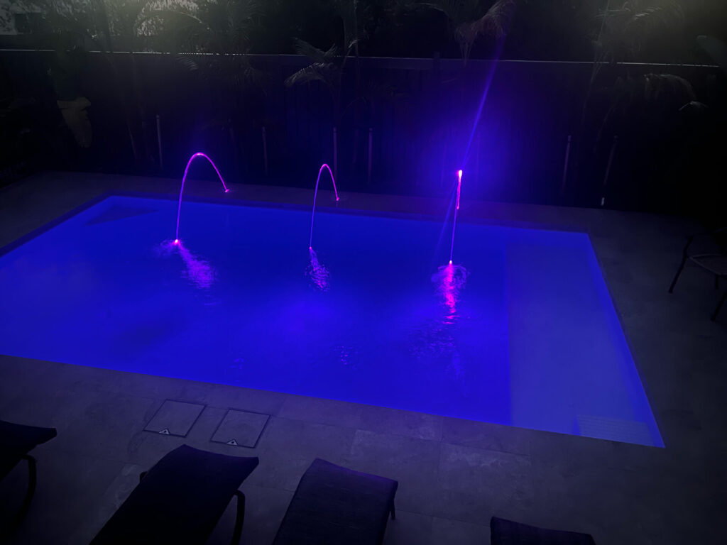 Plenty swimming pool at night with lights project by Venetian Pools